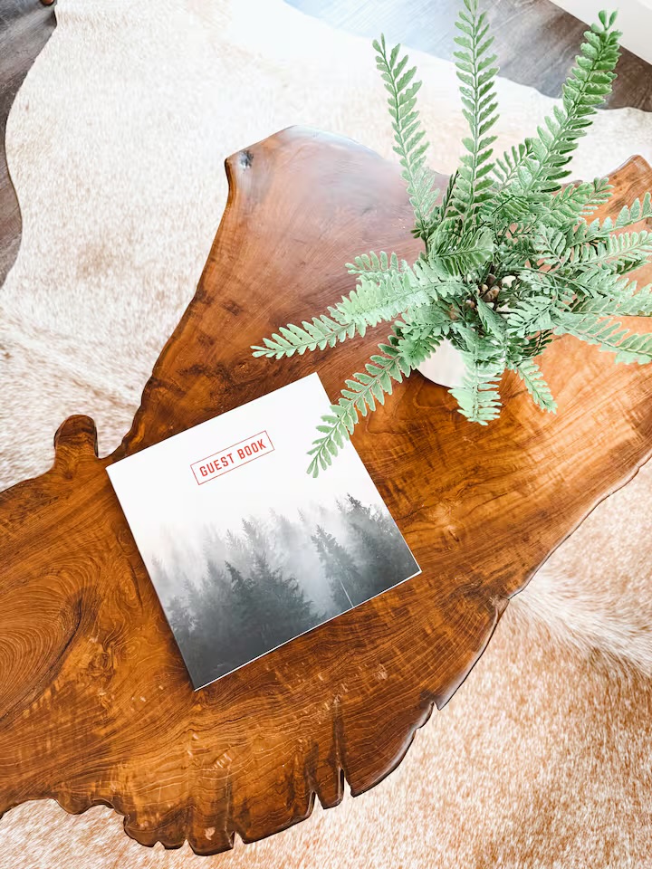 Tiny Timber live-edge coffee table with guest book and greenery