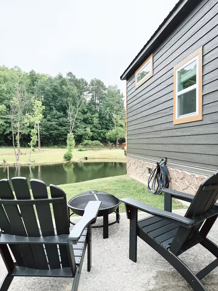 Tiny Timber patio with Adirondack chairs and fire pit overlooking the pond
