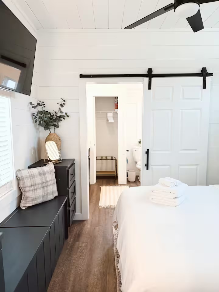 Tiny Timber bedroom with barn door open to the bathroom and closet