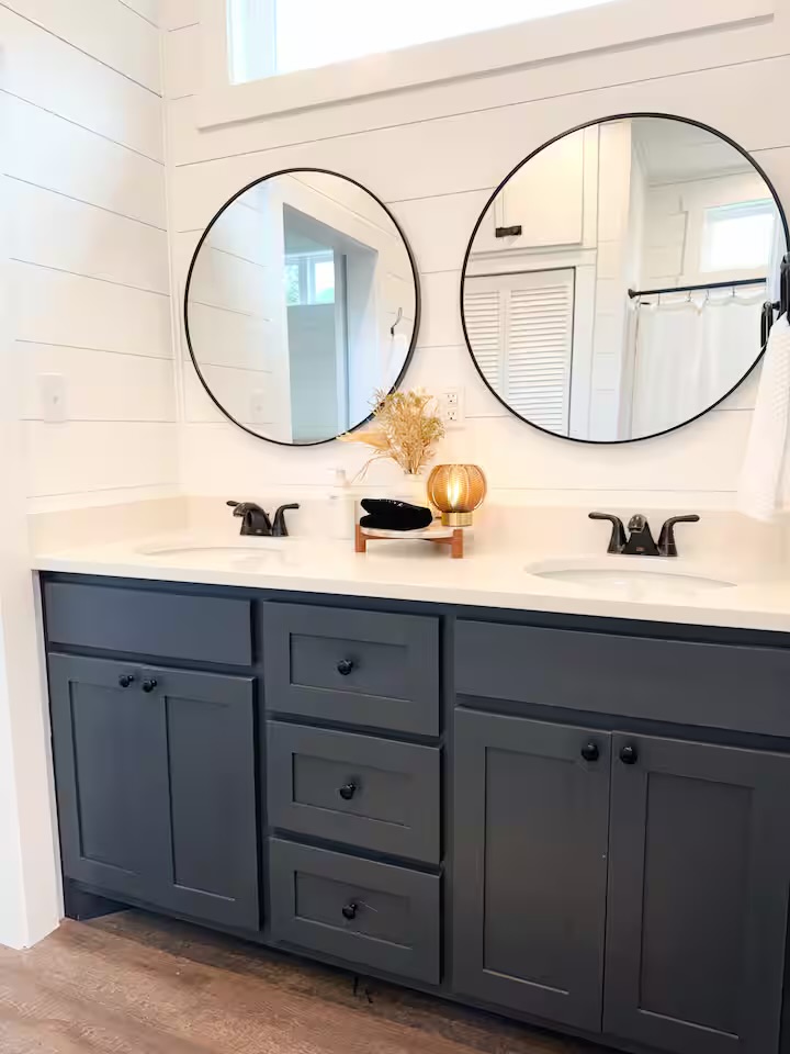 Tiny Timber double vanity with round mirrors and navy cabinets
