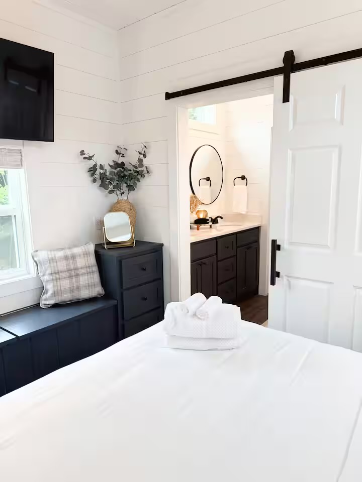 Tiny Timber bedroom looking through barn door to bathroom
